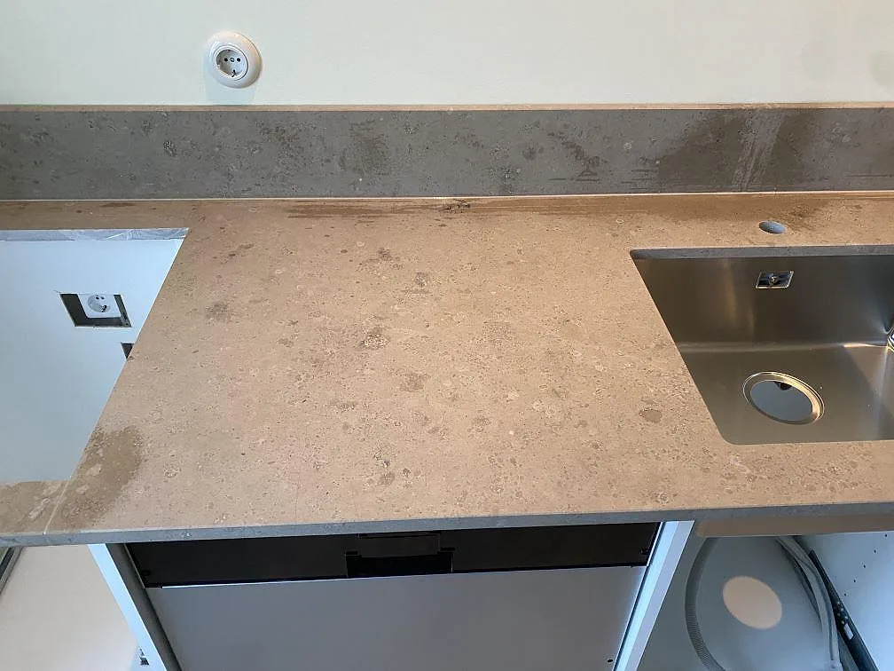 Närbild av matt Jura Grey bänkskiva med diskho, stänkkant och öppen köksstomme i Malmö.