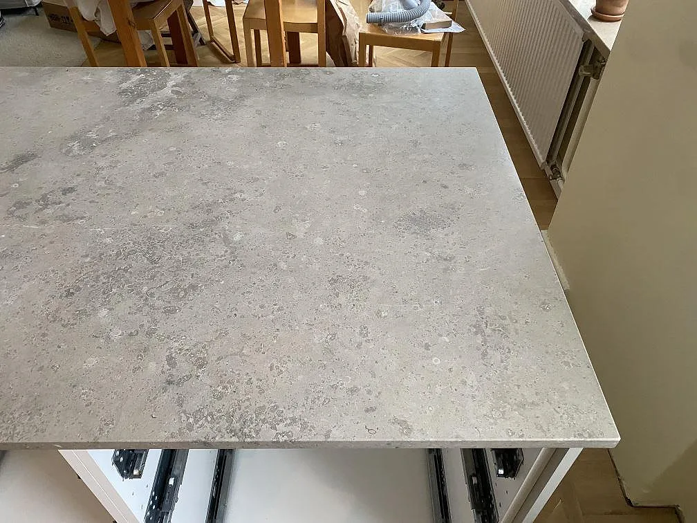 Köksö med matt Jura Grey kalksten och fossilpräglad yta i ett kök i Malmö.