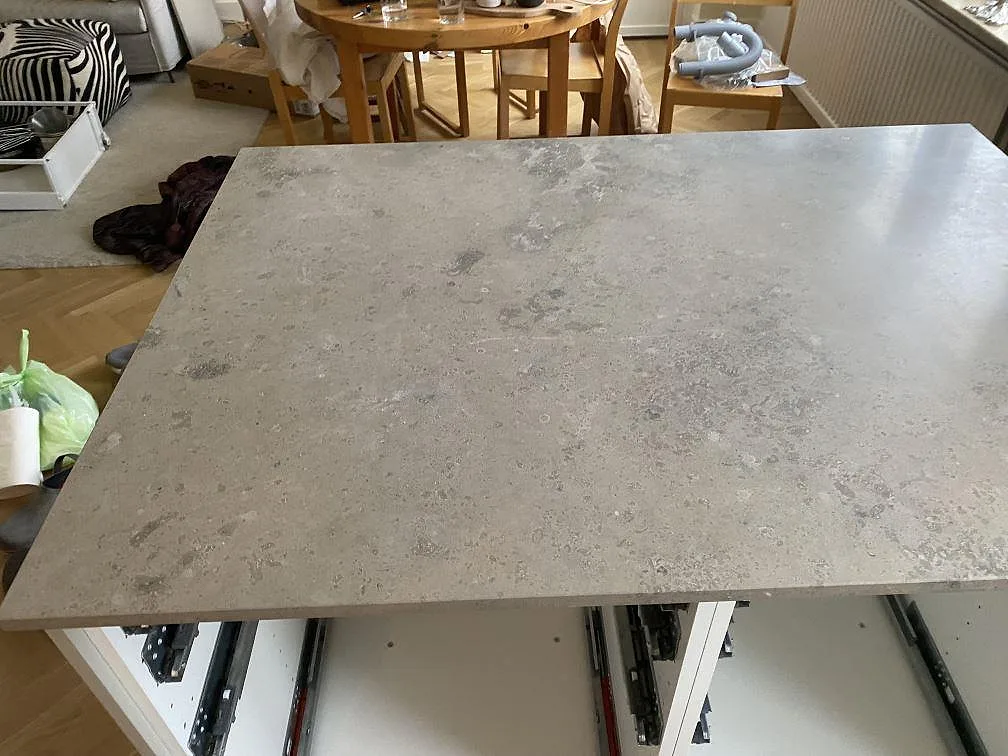 Närbild av köksö i matt Jura Grey med grå kalkstensyta och synliga fossilmönster i Malmö.