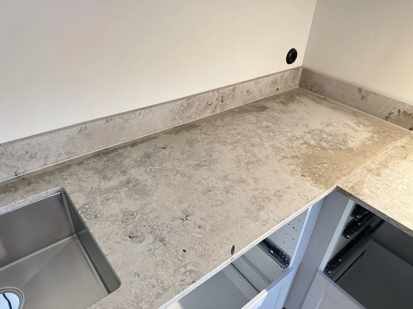 Hörnparti i matt Jura Grey som köksbänkskiva med uppvikt stänkkant och synlig fossilådring i Malmö.