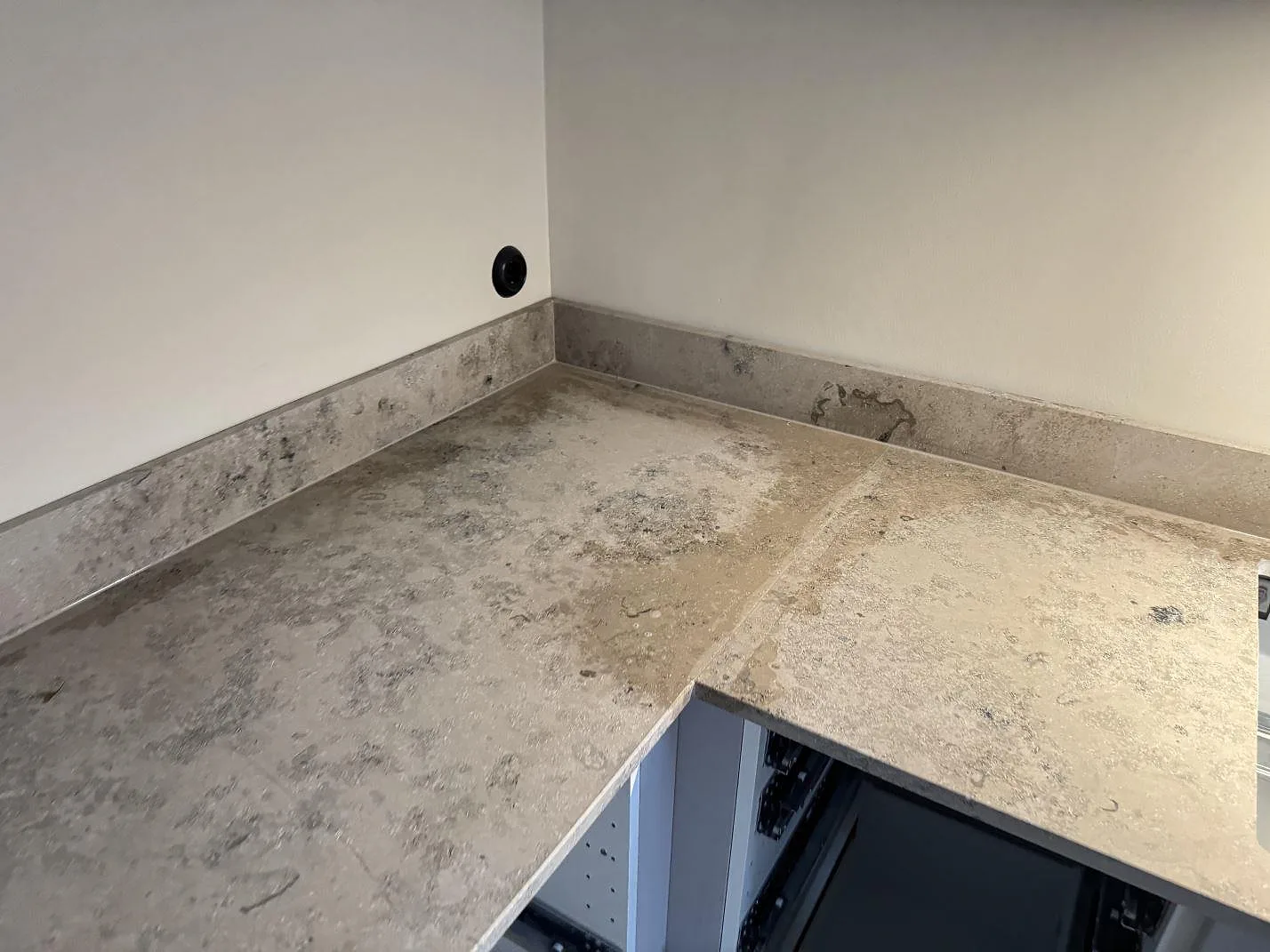 Närbild av hörnet på köksbänkskiva i matt Jura Grey med stänkkant och grå ådring i Malmö.
