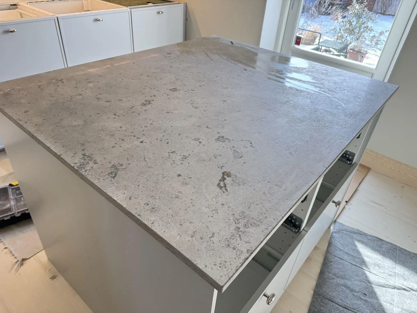 Köksö i Jura Grey kalksten med matt yta och dagsljus från fönstret i ett kök i Malmö.