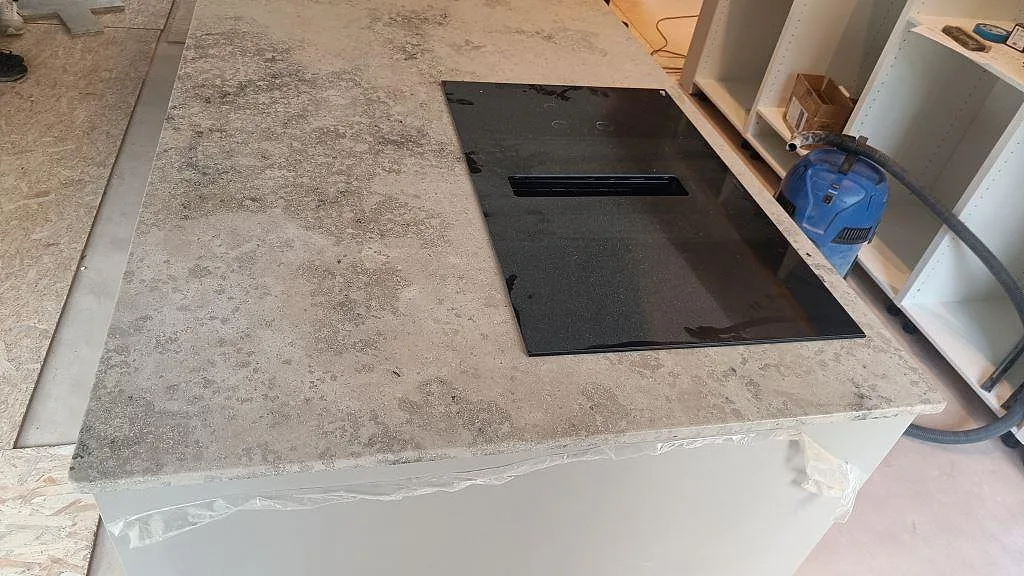Detalj av svart häll i matt Jura Grey köksbänkskiva med monteringsskydd kvar på köksön i Marstrand.