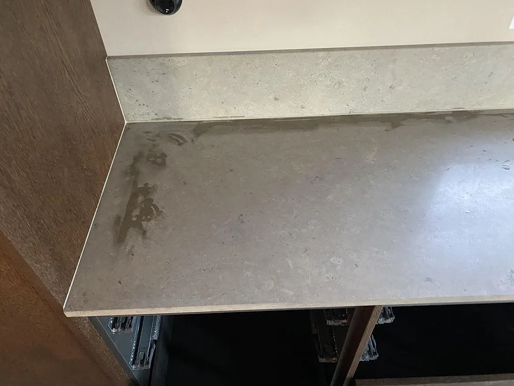 Väggbänk i matt Jura Grey kalksten med låg stänkkant och öppen köksstomme i Mölndal.