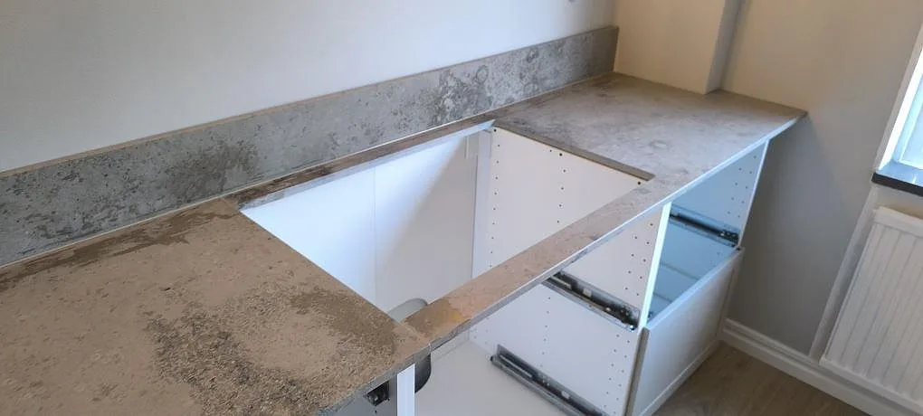 Närbild på matt Jura Grey bänkskiva med utskuren öppning och fossilpräglad grå kalkstensyta i Oxelösund.