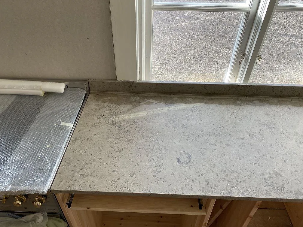 Rak köksbänkskiva i matt Jura Grey kalksten med grå ådring och stänkkant i Ronneby.