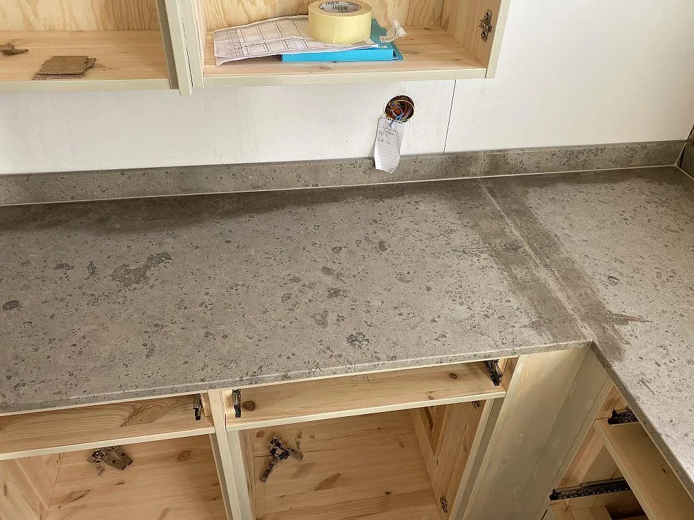 Lång bänkskiva i matt Jura Grey kalksten med lugn grå ådring och stänkkant i Ronneby.