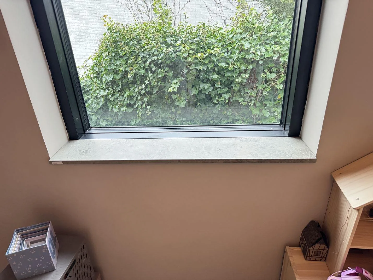 Fönsterbänk i Jura Grey kalksten, matt yta, monterad under ett svart fönster i Søborg.