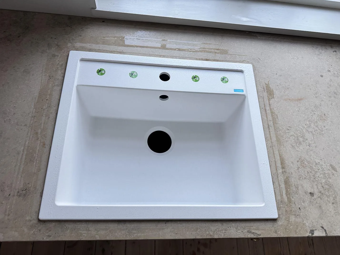 Detalj av vit diskho i bänkskiva av matt Jura Grey kalksten med fossiltecknad yta i Stueetagen Sorø.