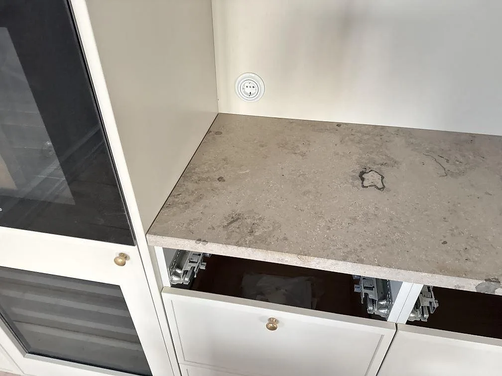 Matt Jura Grey bänkskiva på ljus köksinredning under montering, med öppen lådfront i Stueetagen Sorø.