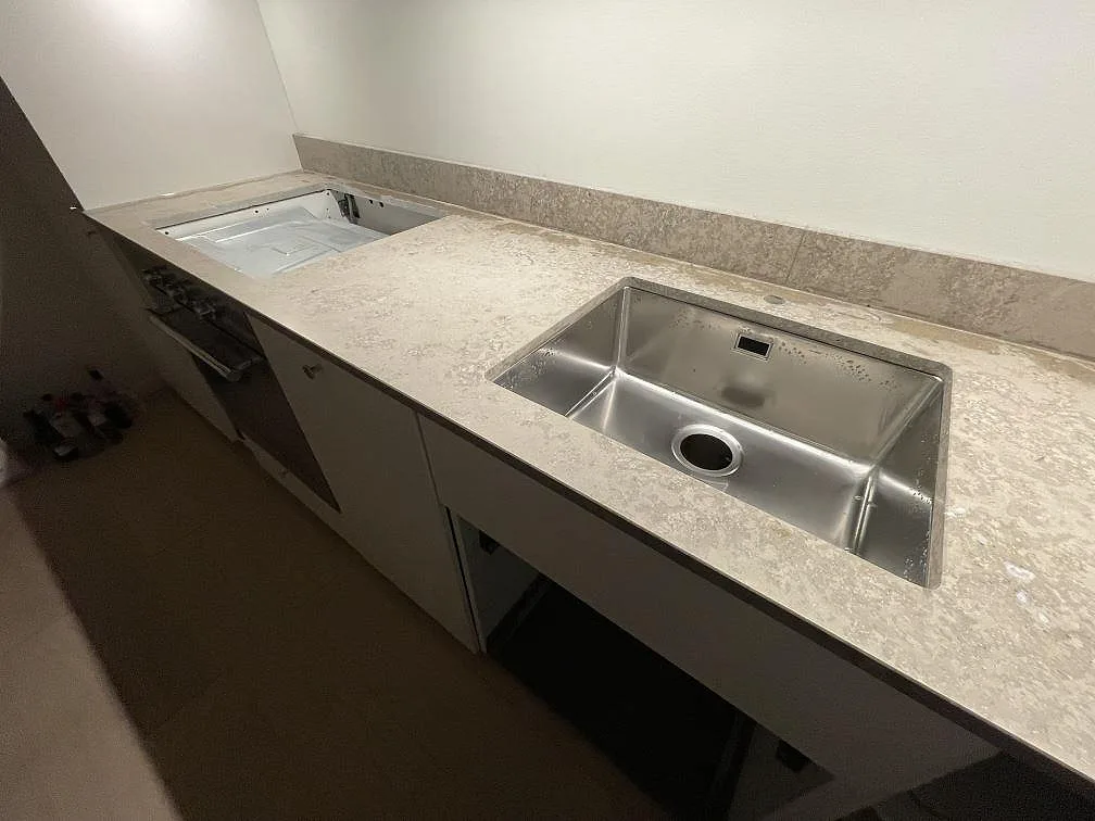 Matt Jura Grey bänkskiva med plats för häll och en underlimmad rostfri diskho längs köksbänken i Sundbyberg.