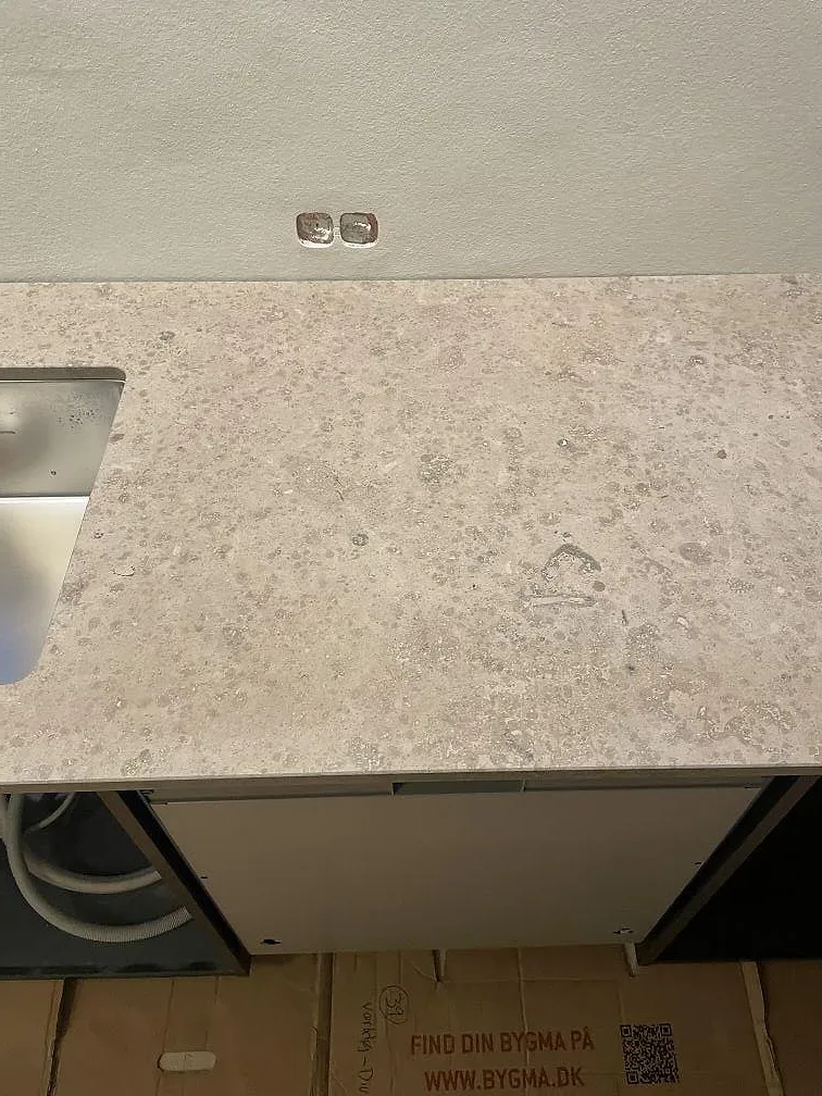 Köksbänkskiva i Jura Grey kalksten med tydlig kornig struktur och fossilavtryck, sett ovanifrån, i ett kök i Svendborg.