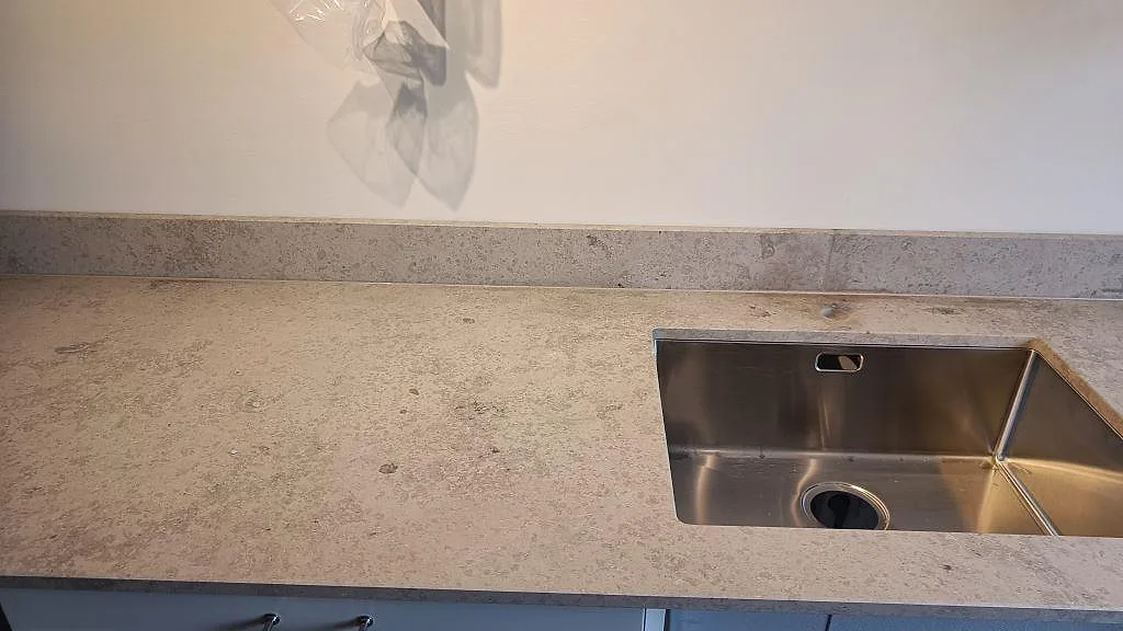 Köksbänkskiva i matt Jura Grey kalksten med underlimmad rostfri diskho och låg stänkkant i Västra Frölunda.
