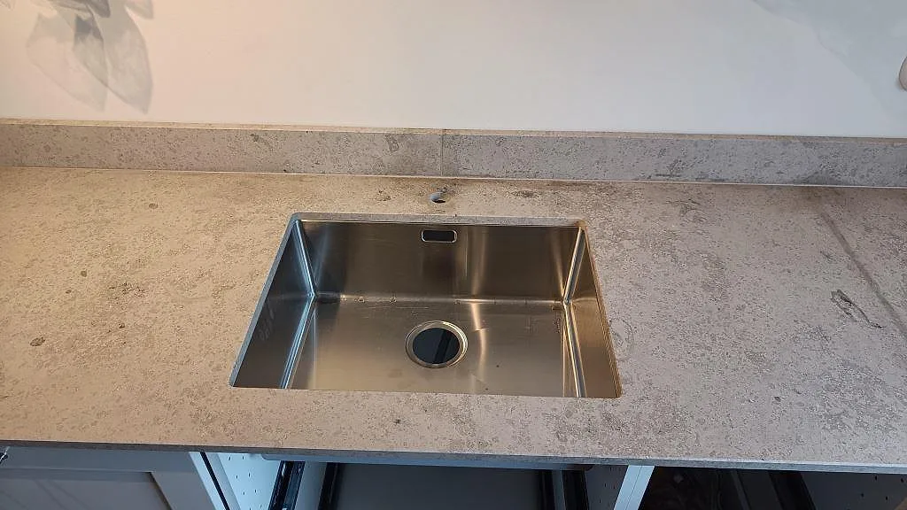 Diskzon i Västra Frölunda med Jura Grey kalksten, matt finish och en rostfri diskho monterad under stenen.