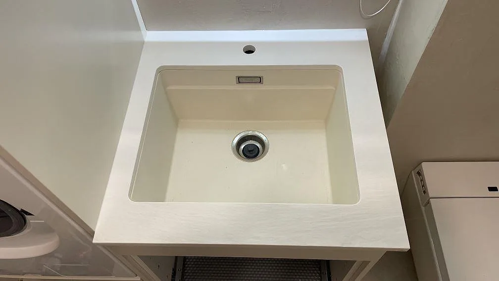 Bänkskiva i Laminam Bianco Spacco, ljus strukturerad keramik, med rektangulär ho och blandarhål i Malmö.