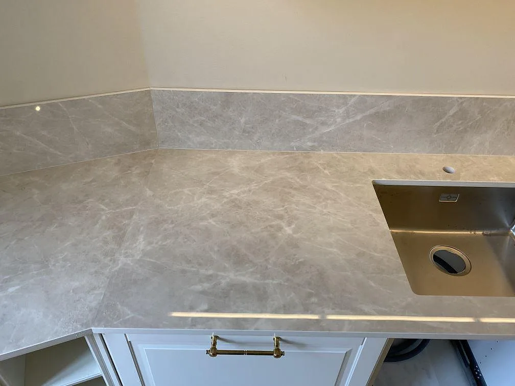 Köksbänkskiva i polerad Laminam Diamond Cream keramik med rostfri diskho, kranhål och stänkskydd i Malmö.
