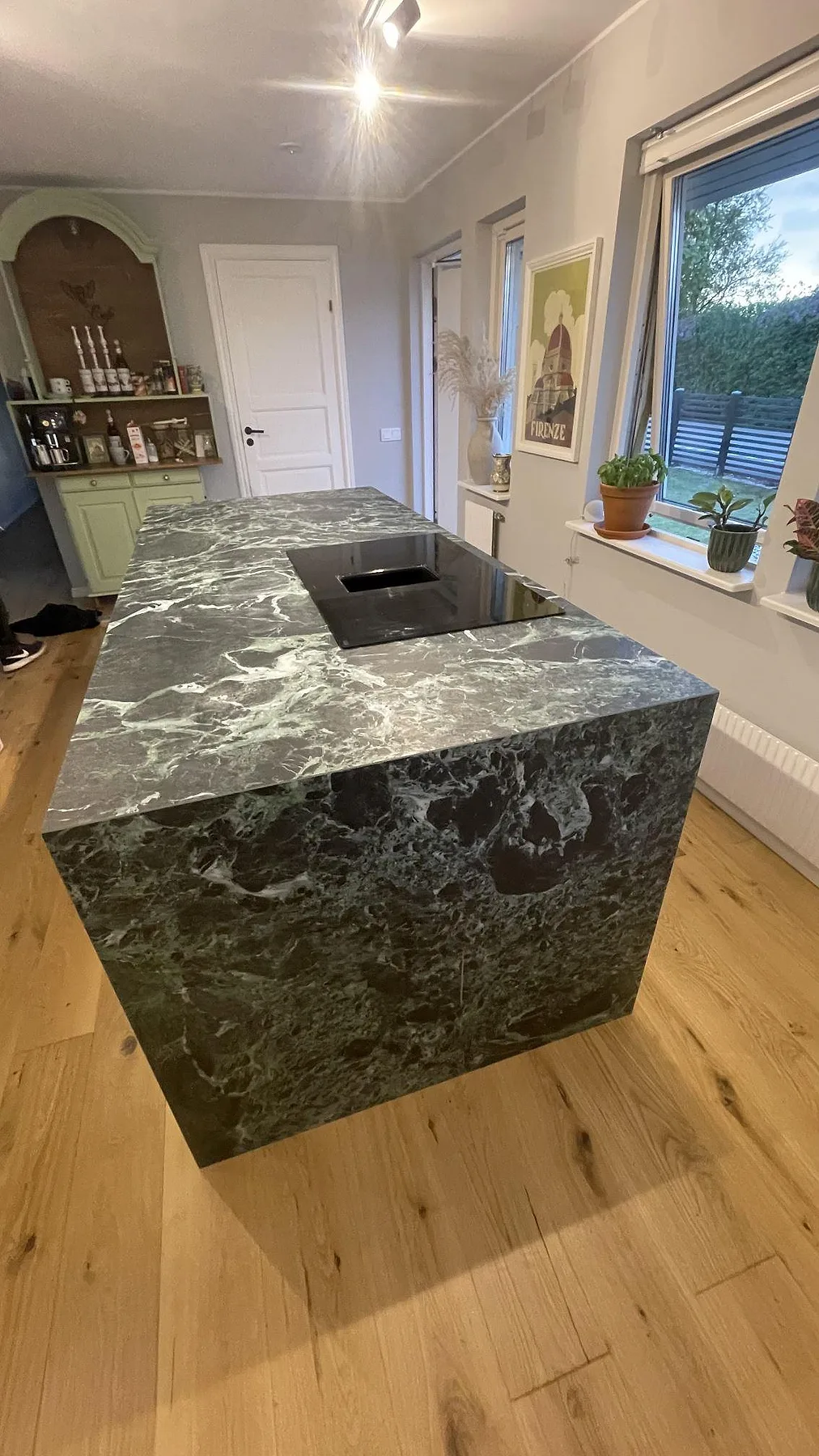 Köksö i Laminam Verde Alpi med induktionshäll och heltäckande sidokant i grön keramik, i ett kök i Svedala.