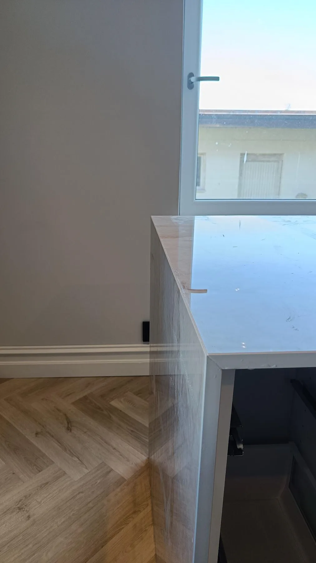 Detalj av polerad Makrana keramik vid köksö och fönster, med reflekterande yta och neddragen sida i Helsingborg.