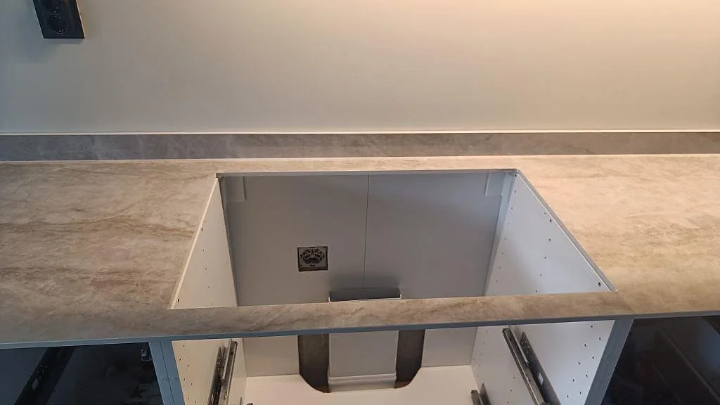 Urtagning i polerad Makrana keramik på bakre köksbänk med stänkkant och öppna köksstommar i Kungälv.