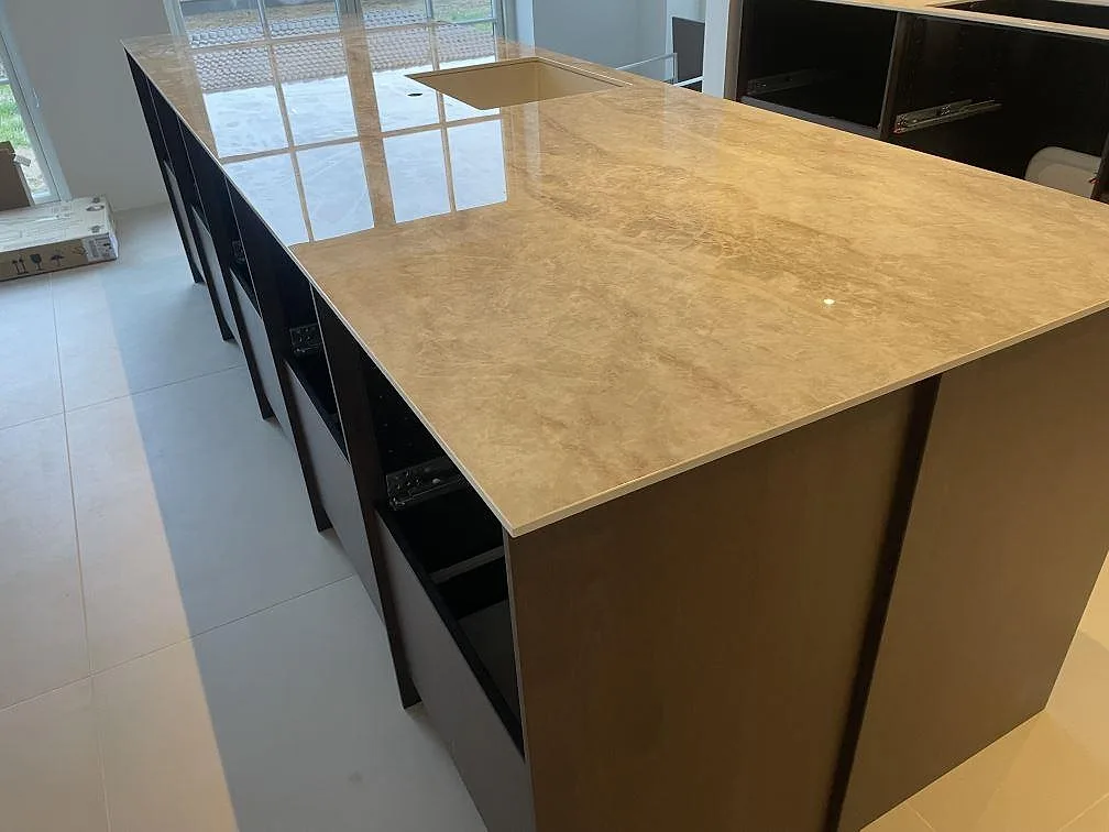 Närbild av köksö i polerad Makrana keramik med ljus diskho och öppna stommar i Middelfart.