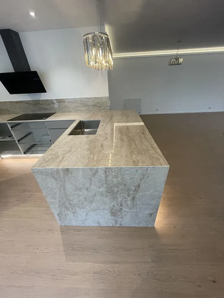 Detalj av den sidoklädda kanten på köksön i polerad Makrana keramik i Staffanstorp, där ådringen löper ner längs stenens framsida.