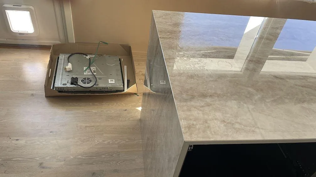 Sidovy av köksö i polerad Makrana keramik med blank reflekterande ovansida i Tanumshede.