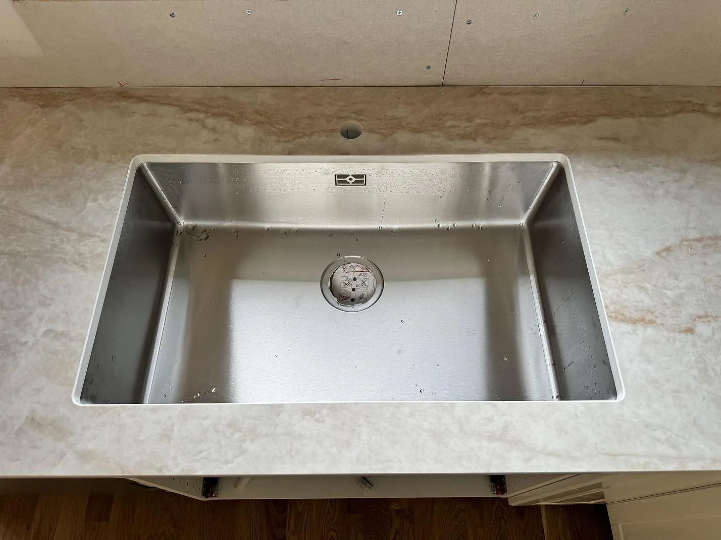 Detalj av diskhodel i polerad Makrana keramik med diskho i köksbänkskivan i Vinslöv.