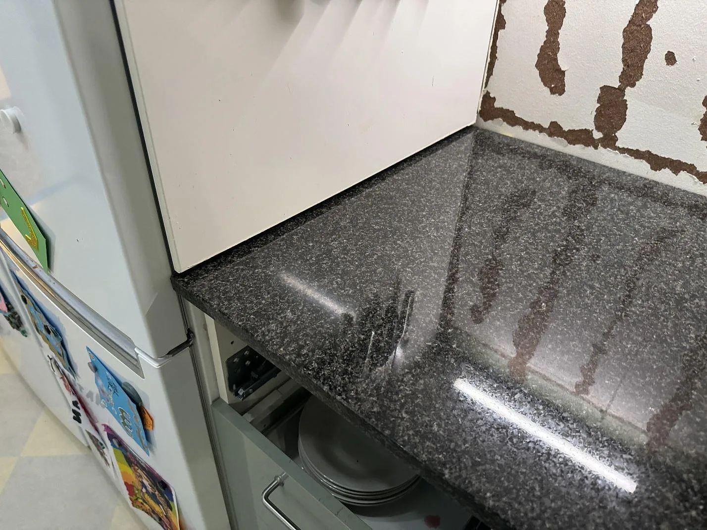 Närbild av blank polerad Nero Africa granit intill kyl och vägg under färdigställande i Floda.