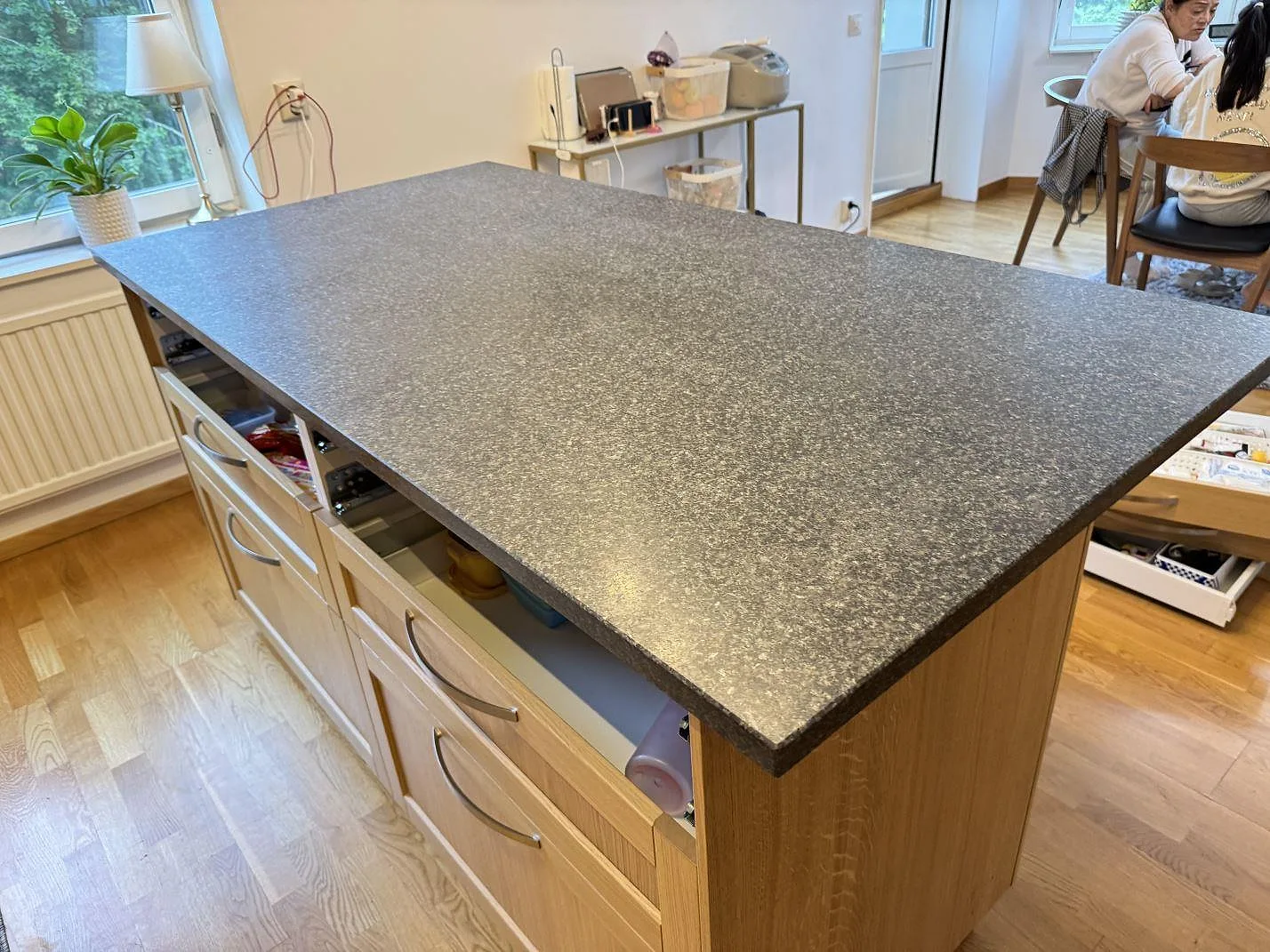 Installerad köksbänkskiva i matt Nero Africa granit på träinredd köksö under montering i Göteborg.