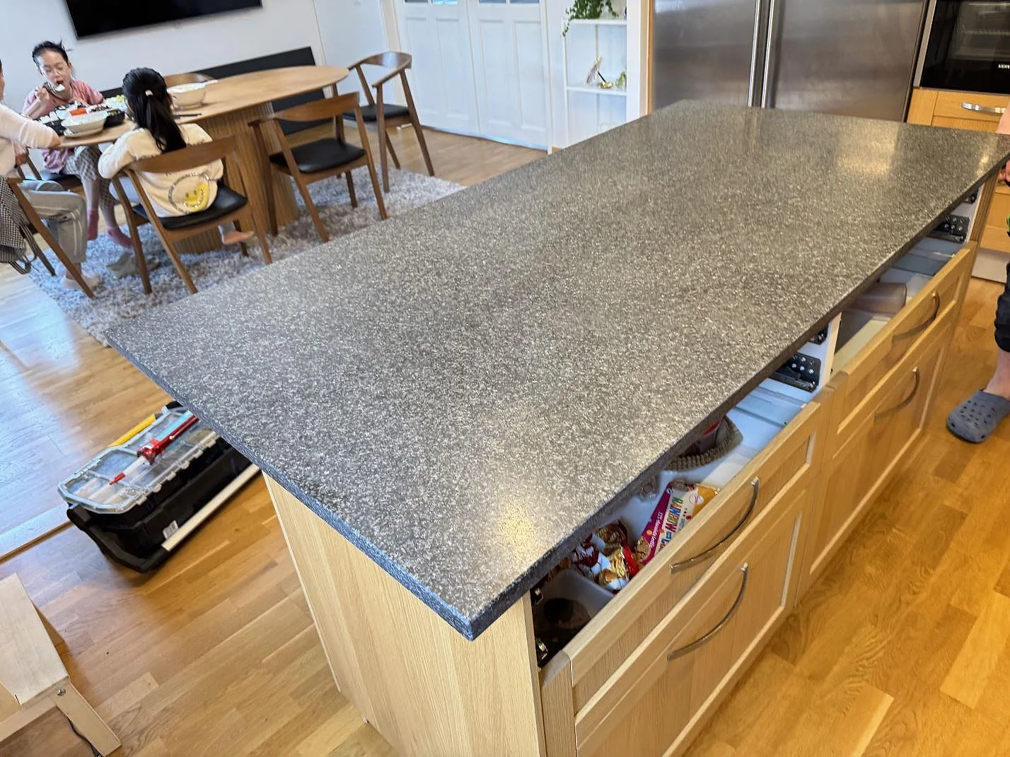 Köksbänkskiva i matt Nero Africa granit, 30 mm, som stor köksö med synlig kant i ett kök i Göteborg.