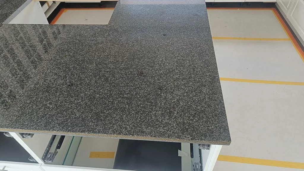 Närbild av köksö i polerad Nero Africa granit med utskärning och synlig stenkant i Halmstad.