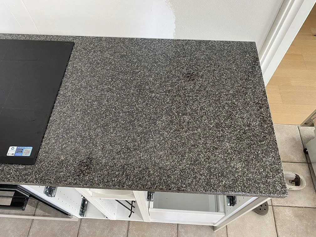 Arbetsyta bredvid häll i polerad Nero Africa granit, monterad på öppna köksstommar i Hjärnarp.