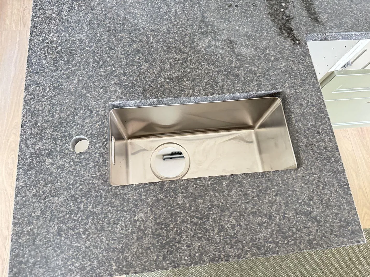 Topvy av matt Nero Africa granit med rostfri diskho och kranhål i köksbänkskivan i Höör.