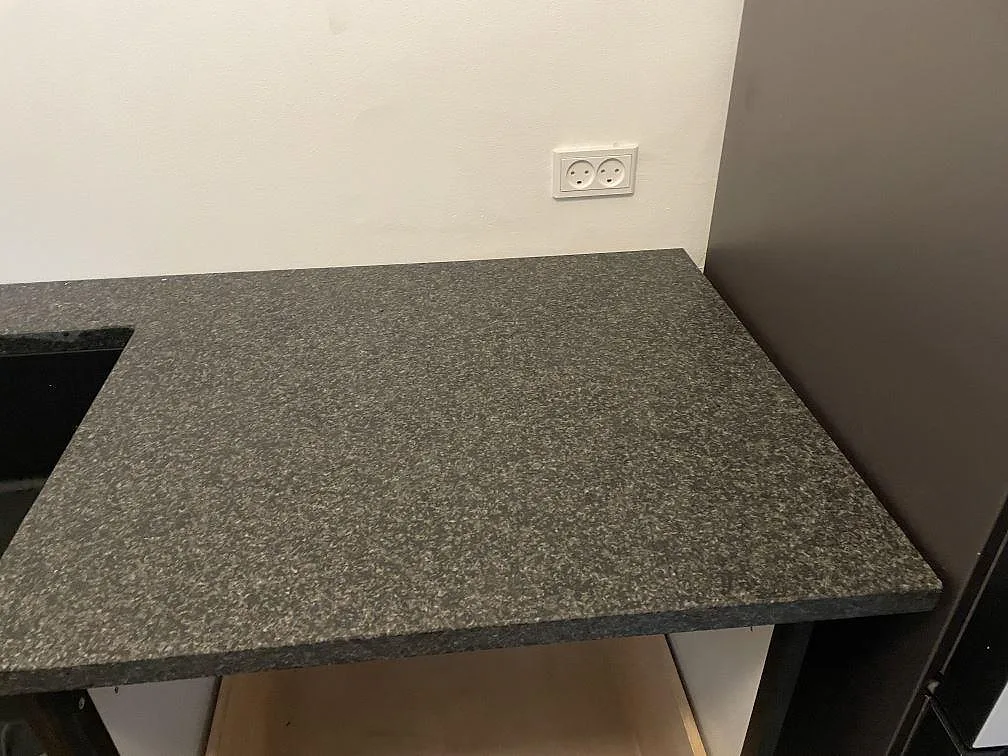 Närbild på den matta köksbänkskivan i Nero Africa granit med synlig kornig struktur i ett kök i Köbenhavn.
