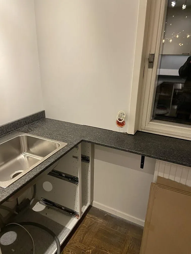 Köksbänkskiva i svart granit Nero Africa med rostfri diskho och granitfönsterbänk i ett kök i Malmö.