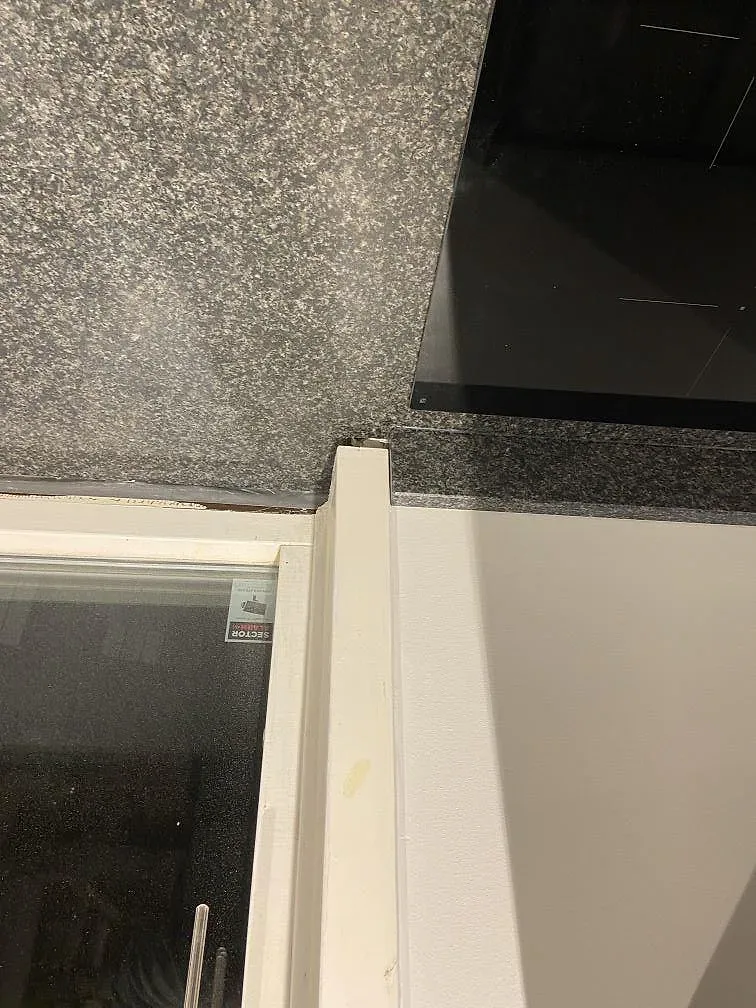Uppvikt stänkkant och granitfönsterbänk i svart Nero Africa, matt yta, i ett kök i Malmö.