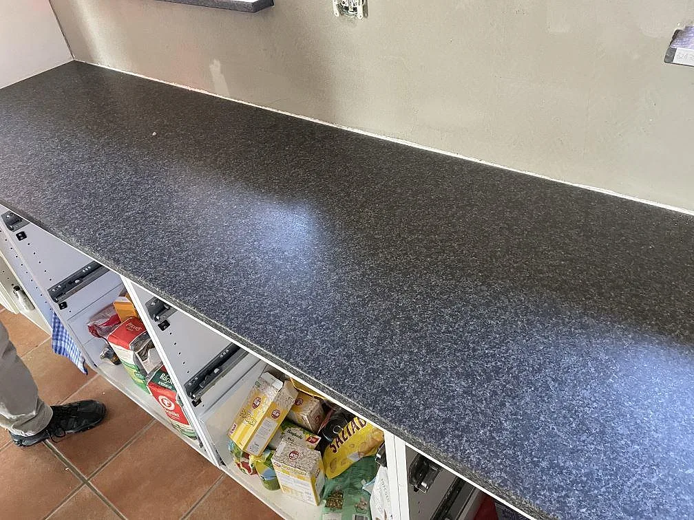 Matt svart köksbänkskiva i Nero Africa-granit installerad ovanpå köksstommar i ett kök i Staffanstorp.