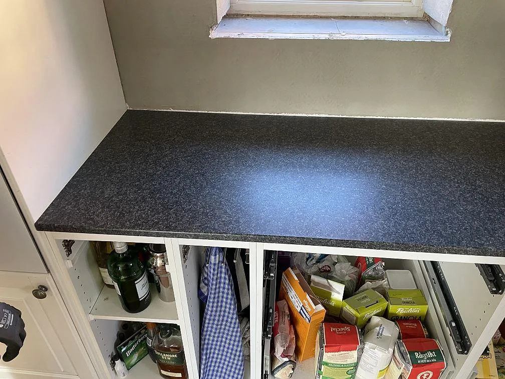 Närbild på köksbänkskiva i Nero Africa-granit med matt, granulerad yta i ett kök under montering i Staffanstorp.