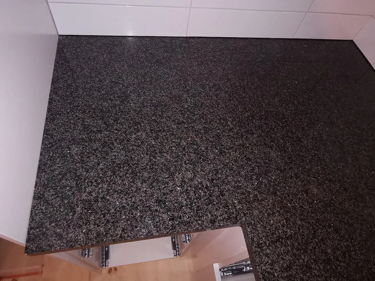 Ovanvy av polerad Nero Africa granitbänk med induktionshäll, mörk granit i ett kök i Vaggeryd.