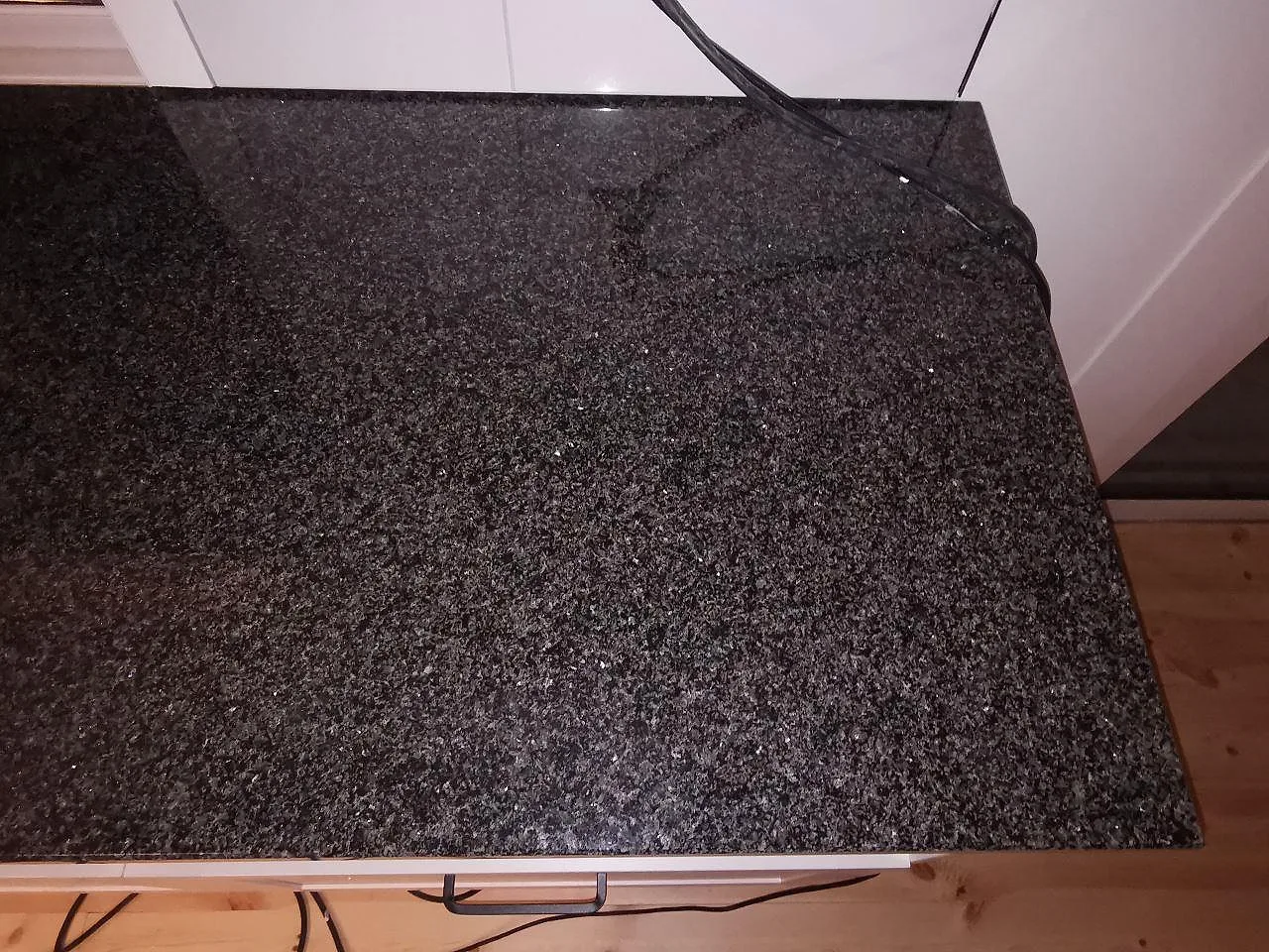 Polerad Nero Africa granitbänk i ett kök i Vaggeryd, mörk spräcklig stenyta installerad mot väggen.