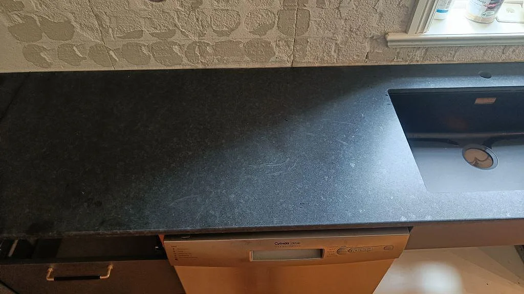 Bänkskiva i matt Nero Assoluto granit med infälld häll på en köksbänk i Ängelholm.