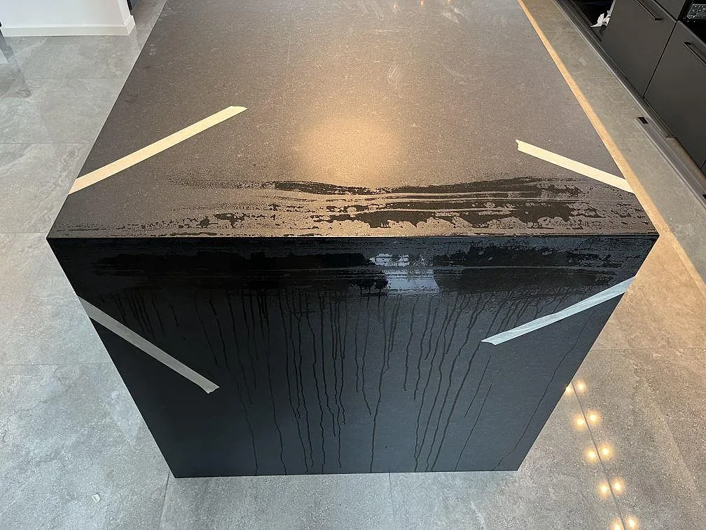 Matt svart granitbänkskiva i Nero Assoluto med synlig framkant på en köksö, installerad under montering i ett kök i Ängelholm.
