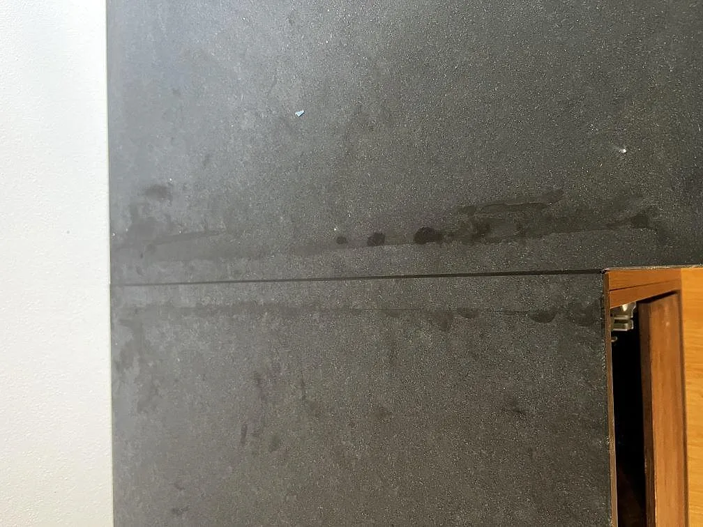 Topvy av skarv och mörk matt Nero Assoluto granit på köksbänkskiva i Assens.