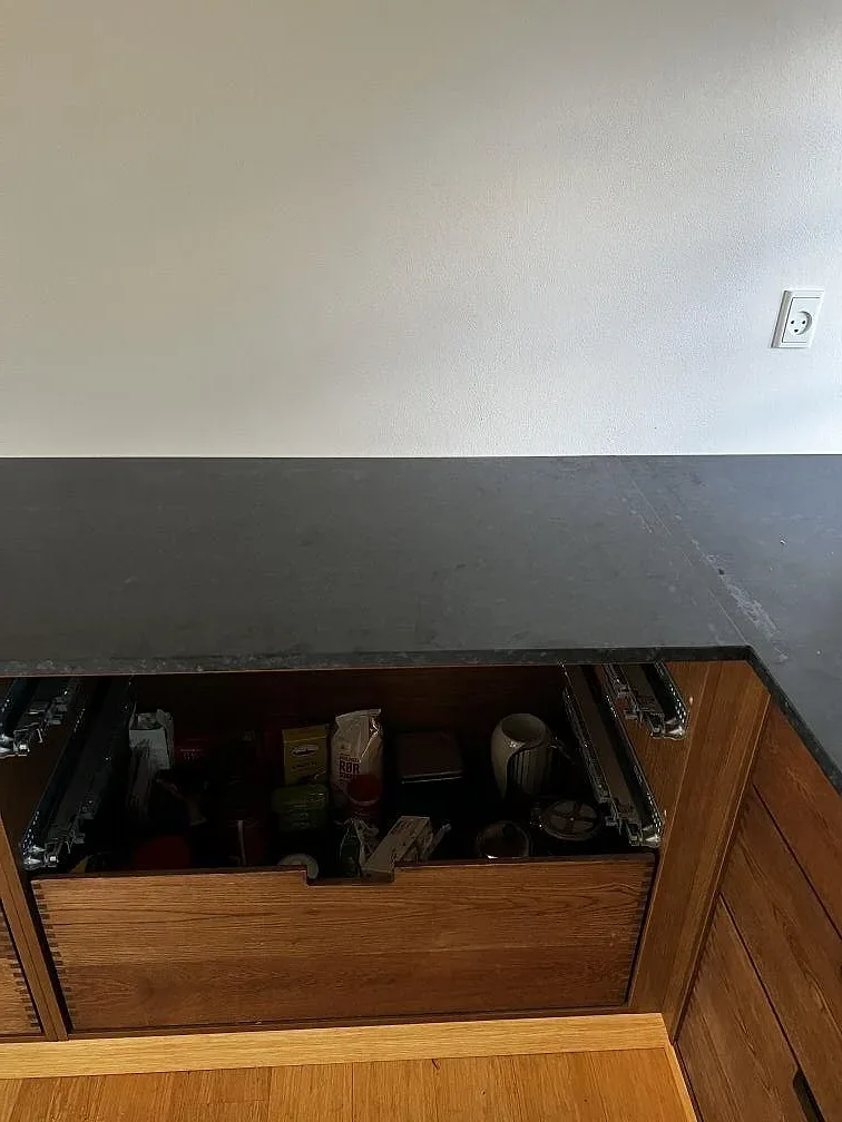 Detalj av matt Nero Assoluto granit över utdragbar träinredning i köket i Assens.