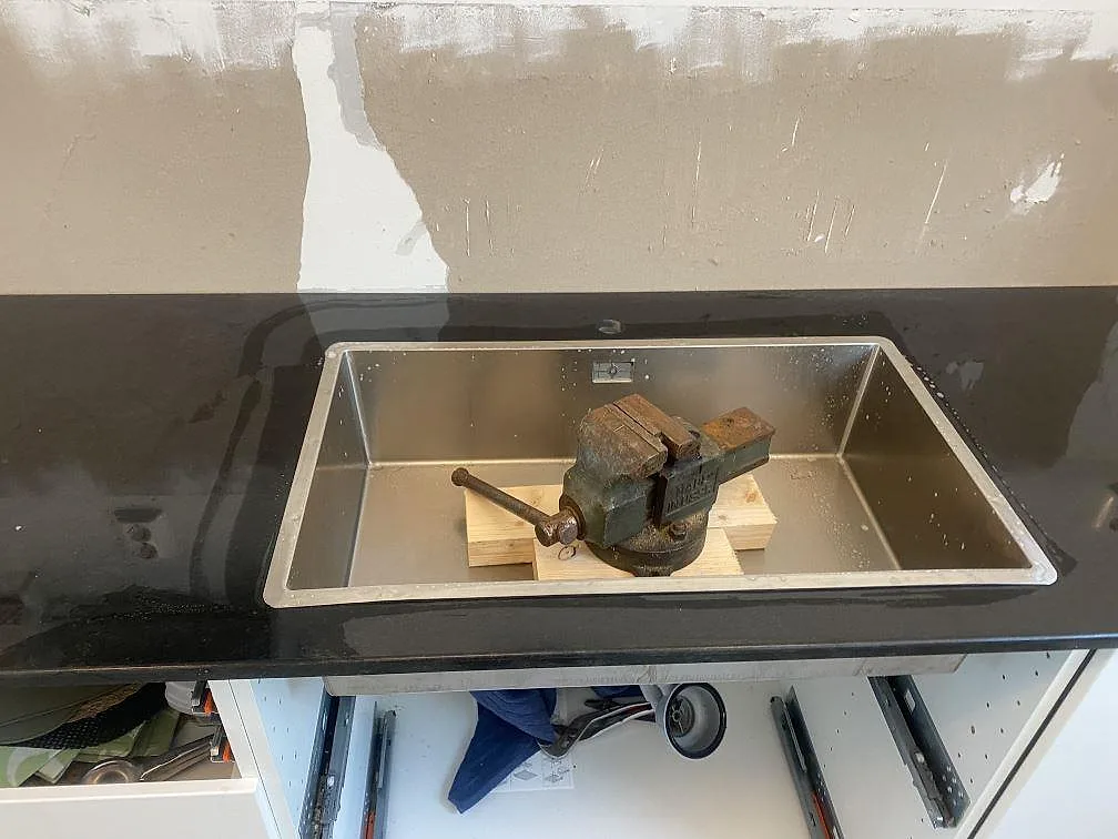 Polerad Nero Assoluto granit med rostfri diskho i ett kök under montering i Båstad.