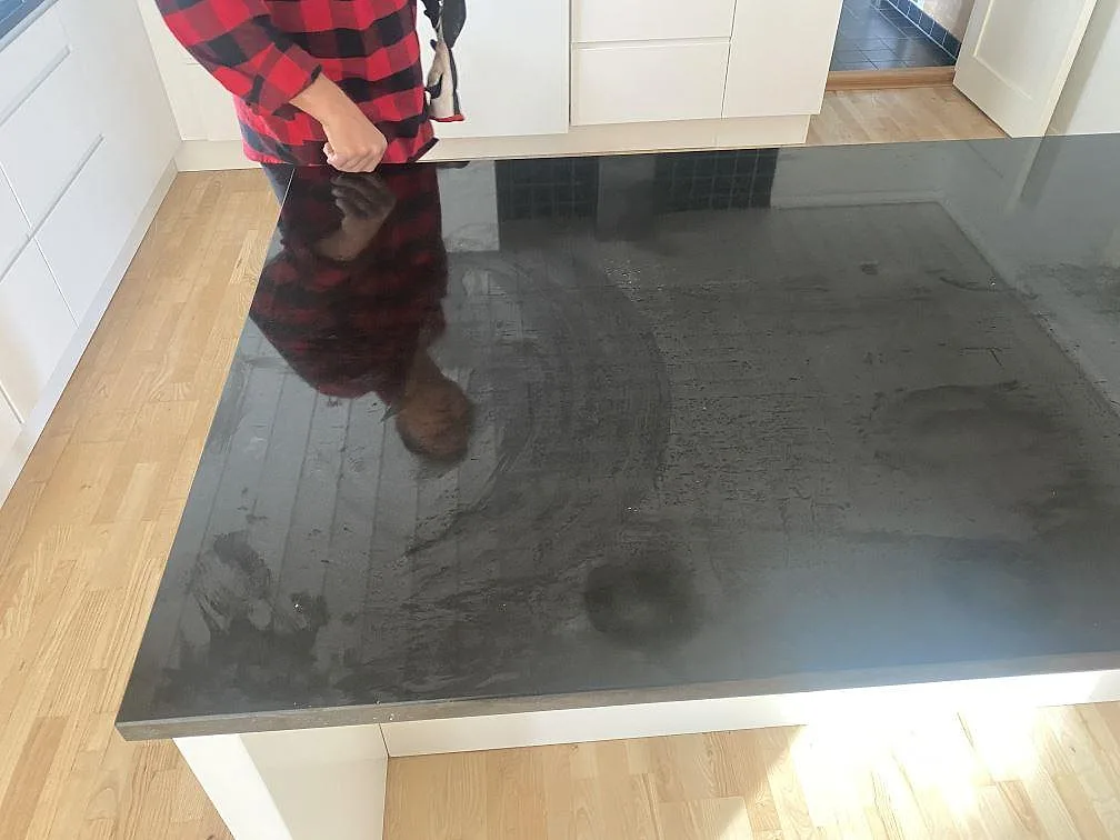 Blank köksbänkskiva i Nero Assoluto granit på köksö i Bjärred, fotograferad ovanifrån under leverans.
