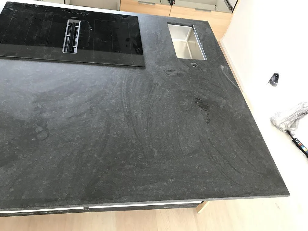 Köksö i Nero Assoluto med infälld Siemens induktionshäll och underlimmad diskho i svart matt granit i ett kök i Bunkeflostrand.