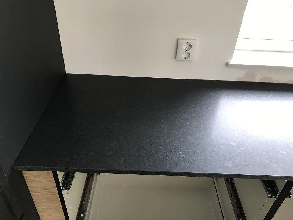 Bänkskiva i svart granit Nero Assoluto med matt yta längs köksväggen vid fönstret i ett kök i Bunkeflostrand.
