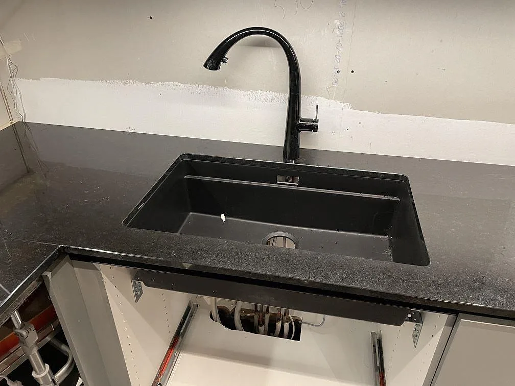 Närbild på svart Silgranit-diskho i polerad Nero Assoluto granit med synlig stenstruktur i Dalby.