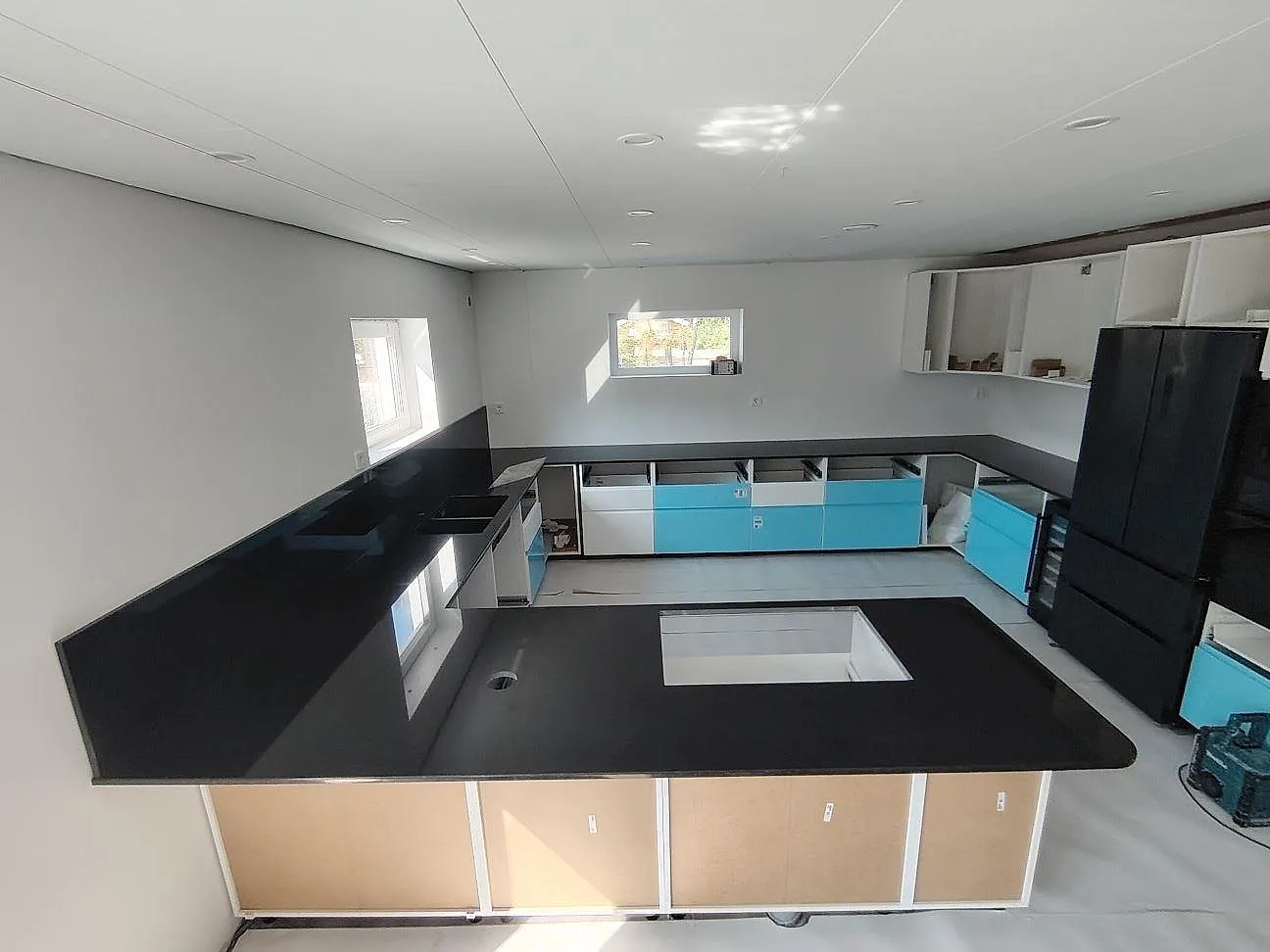 Köksbänkskiva i svart Nero Assoluto granit, polerad, monterad i ett U-format kök under renovering i Eskilstuna.
